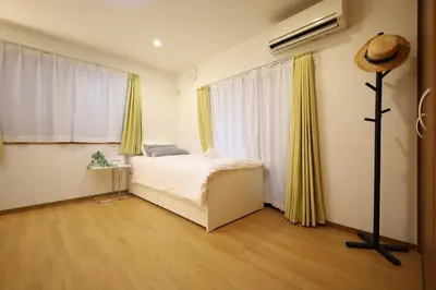 a bedroom with a bed and a large window at \u65b0\u5bbf\u521d\u53f0\u30a2\u30d1\u30fc\u30c8 in Tokyo