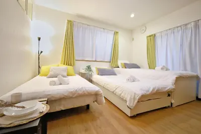 a bedroom with two beds and a table at \u65b0\u5bbf\u521d\u53f0\u30a2\u30d1\u30fc\u30c8 in Tokyo