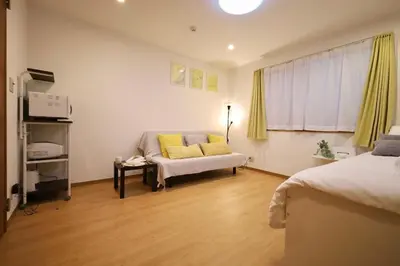 a living room with a couch and a window at \u65b0\u5bbf\u521d\u53f0\u30a2\u30d1\u30fc\u30c8 in Tokyo