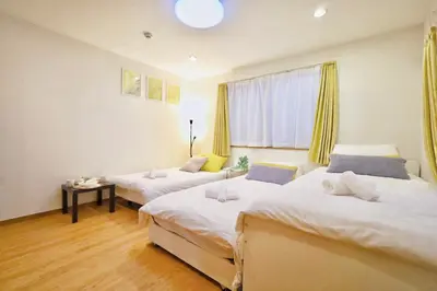 a bedroom with two beds and a window at \u65b0\u5bbf\u521d\u53f0\u30a2\u30d1\u30fc\u30c8 in Tokyo