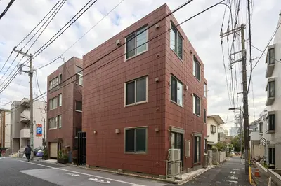 a red building on the side of a street at K1 4min from nearest station 7min to shinjuku area101 in Tokyo