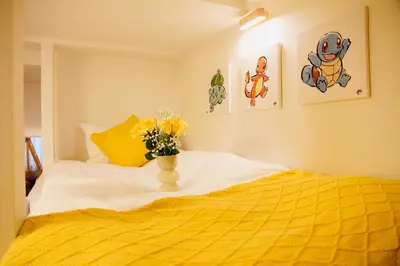 a yellow bed with a vase of flowers on it at Fun Haven Itabashi in Tokyo