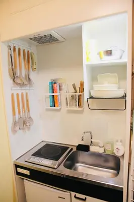 a kitchen with a sink and a stove and utensils at Fun Haven Itabashi in Tokyo