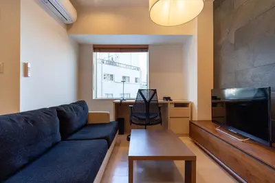 a living room with a couch and a tv and a table at \u6771\u6025\u30b9\u30c6\u30a4\u9752\u5c71 in Tokyo