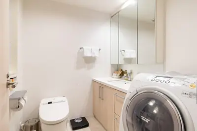 a white bathroom with a washing machine in it at \u6771\u6025\u30b9\u30c6\u30a4\u9752\u5c71 in Tokyo