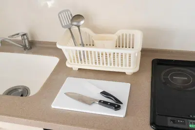 a kitchen counter with a knife and a basket of utensils at \u6771\u6025\u30b9\u30c6\u30a4\u9752\u5c71 in Tokyo