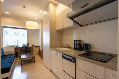 a kitchen with a sink and a couch in a room at \u6771\u6025\u30b9\u30c6\u30a4\u9752\u5c71 in Tokyo