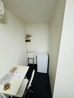 a small white room with a table and chairs at Toho so Inn in Tokyo