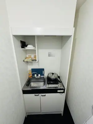 a small kitchen with a sink and a stove at Toho so Inn in Tokyo