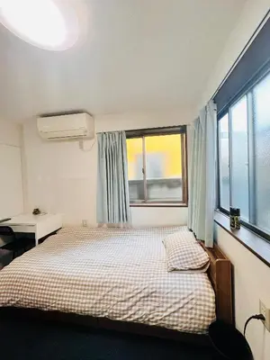a small bedroom with a bed and a window at Toho so Inn in Tokyo