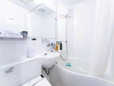 a white bathroom with a sink and a bath tub at APA Hotel Shinjuku Kabukicho Tower in Tokyo