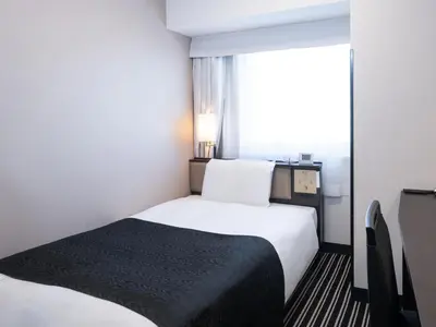 a small room with a bed and a window at APA Hotel Shinjuku Kabukicho Tower in Tokyo