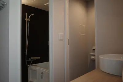 a bathroom with a sink and a bath tub at etoe Hotel Shinjuku in Tokyo