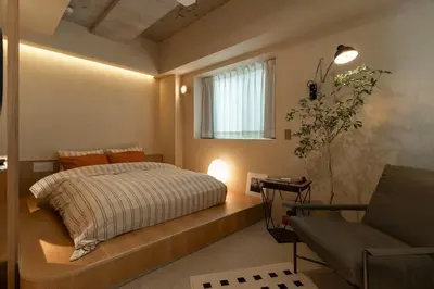 a bedroom with a bed and a window and a couch at etoe Hotel Shinjuku in Tokyo