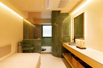 a bathroom with a green tiled wall at etoe Hotel Shinjuku in Tokyo