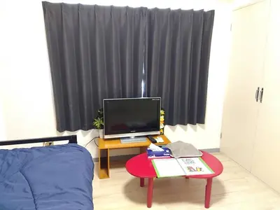 a room with a bed and a table with a television at SunandMoon\u30db\u30c6\u30eb401 in Tokyo