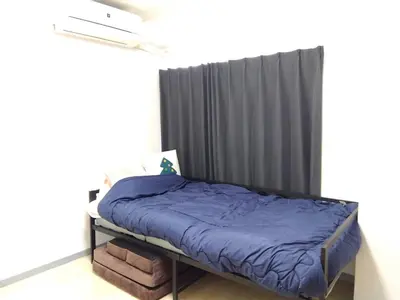 a bed with a blue comforter in a room at SunandMoon\u30db\u30c6\u30eb401 in Tokyo