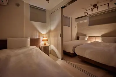 a hotel room with two beds and a mirror at LUXU Urban Shinjuku - 4min to Shinjuku, 10min to Shibuya in Tokyo