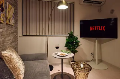 a living room with a couch and a tv and a table at LUXU Urban Shinjuku - 4min to Shinjuku, 10min to Shibuya in Tokyo
