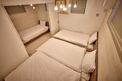 a small room with two beds in it at LUXU Urban Shinjuku - 4min to Shinjuku, 10min to Shibuya in Tokyo