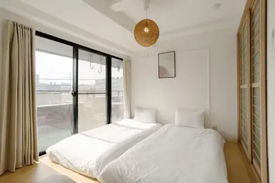 a bedroom with a white bed and a large window at Aurora 4 in Tokyo