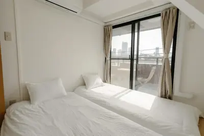 a white bed in a room with a window at Aurora 4 in Tokyo