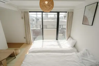 a white bed in a room with a large window at Aurora 4 in Tokyo