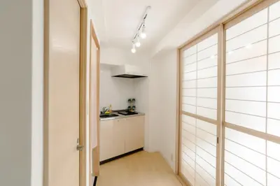 a kitchen with white walls and a door leading into a hallway at Aurora 4 in Tokyo