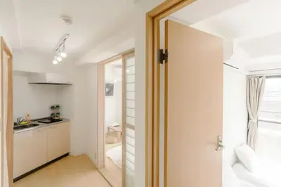 a bathroom with a door leading to a kitchen at Aurora 4 in Tokyo