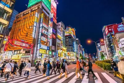 a group of people crossing a street in a busy city at \u3055\u304f\u3089\u30b3\u30f3\u30d5\u30a9\u30fc\u30c8 in Tokyo