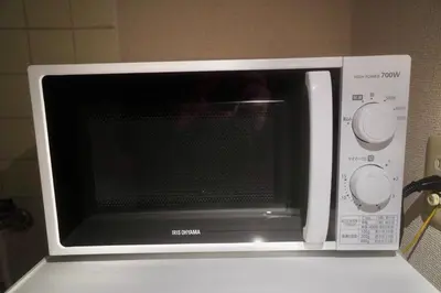 a microwave oven sitting on top of a refrigerator at \u3055\u304f\u3089\u30b3\u30f3\u30d5\u30a9\u30fc\u30c8 in Tokyo
