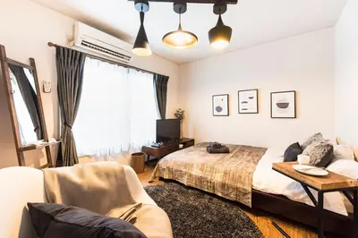 a bedroom with a bed and a couch at Villa Wisteria Kitazawa -apartment hotel- in Tokyo