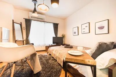 a living room with a bed and a table at Villa Wisteria Kitazawa -apartment hotel- in Tokyo