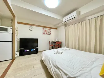 a bedroom with a white bed and a tv at YMK Oshiage 3A in Tokyo