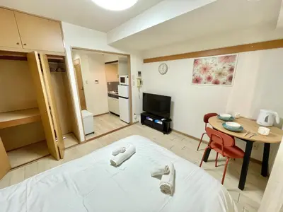 a room with a bed and a table and a kitchen at YMK Oshiage 3A in Tokyo