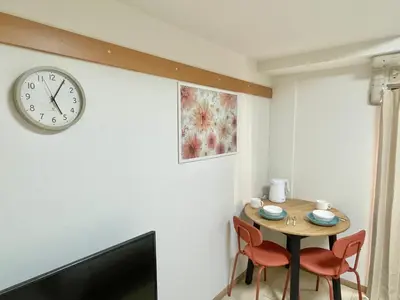 a room with a table and a clock on the wall at YMK Oshiage 3A in Tokyo