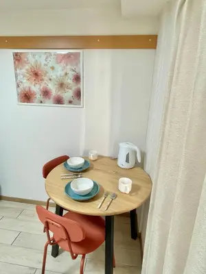 a wooden table with two chairs and plates and a kettle at YMK Oshiage 3A in Tokyo