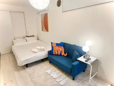 a living room with a blue couch and a bed at Shiro HAKU in Tokyo