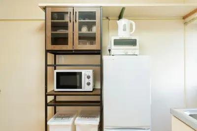 a kitchen with a refrigerator and a microwave at Renovated House Crossroads Katsushika in Tokyo