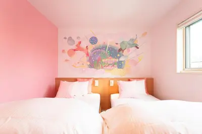 two beds in a bedroom with a painting on the wall at Stay&resort Luce ルーチェ in Urayasu