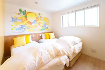 two beds in a small bedroom with a window at Stay&resort Luce ルーチェ in Urayasu
