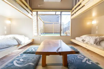 a room with two beds and a table in it at \u5343\u5bff\u5bbf \u7384 in Tokyo