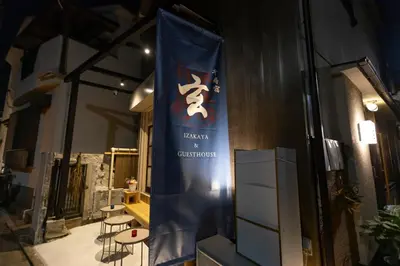 a banner on the side of a building with a table and chairs at \u5343\u5bff\u5bbf \u7384 in Tokyo
