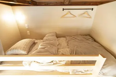 a bed in a small room with hangers at \u5343\u5bff\u5bbf \u7384 in Tokyo