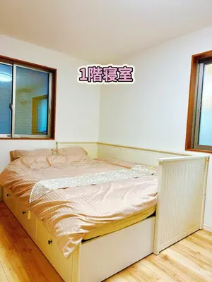 a bed in a white room with a sign on the wall at keisei koiwa little garden in Tokyo
