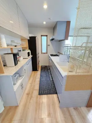 a kitchen with white cabinets and a wooden floor at keisei koiwa little garden in Tokyo