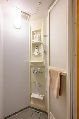 a shower in a small bathroom with a towel at 4min Shinjuku by sub Cozy Mini Room in Tokyo