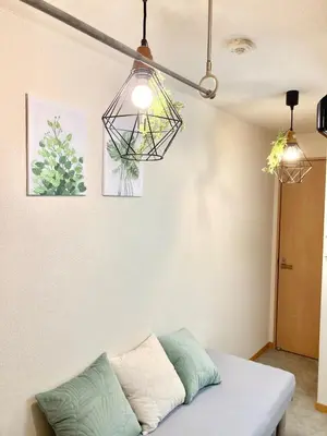 a living room with a couch and two lights at 4min Shinjuku by sub Cozy Mini Room in Tokyo