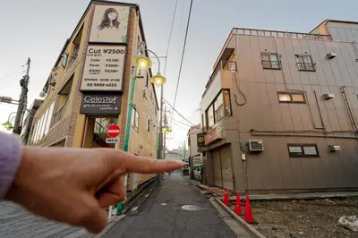 a persons hand pointing at a street with buildings at Palette house Spacious 56 sqm Tokyo Apartment near Station in Tokyo