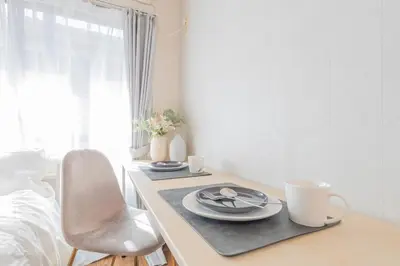 a dining room table with plates and cups on it at The Nest Koenji Cozy Stay near Station Easy Access to Shinjuku in Tokyo